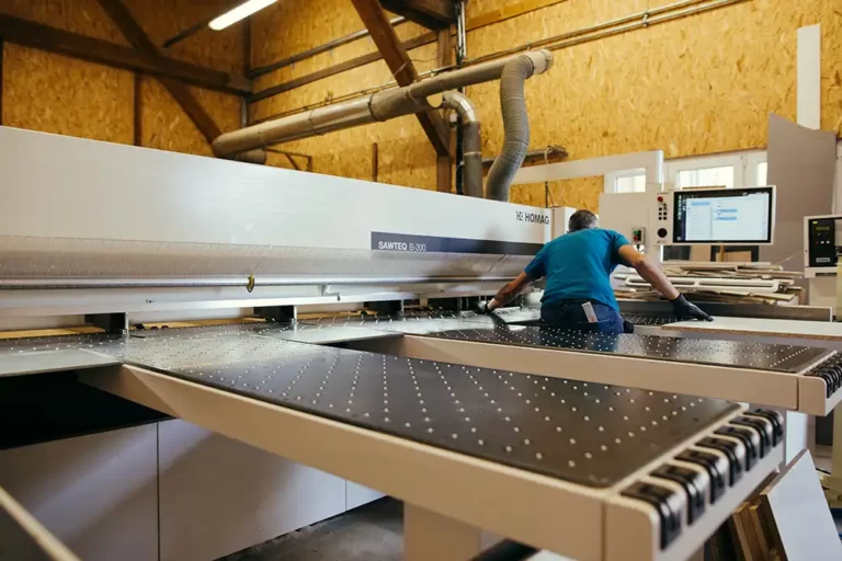 Ebéniste de l'agenceur SCHWITZER au sein de leur atelier sur machine de découpe.