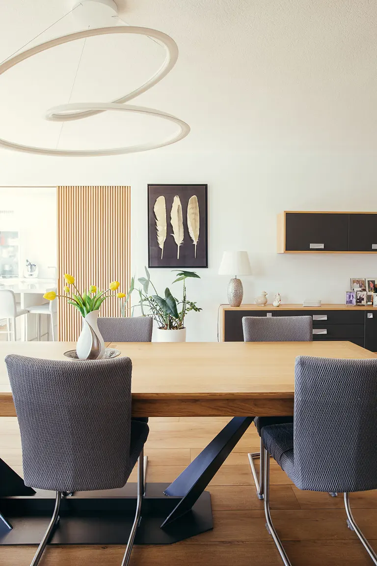 Une salle à manger moderne avec une table en bois et des chaises.