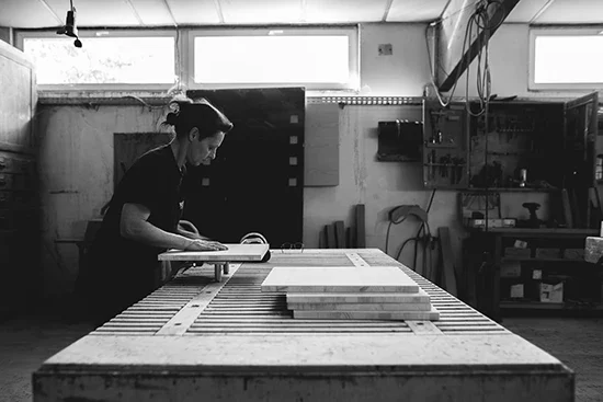 Photo en noir et blanc d'une femme travaillant dans un atelier.